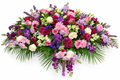 Pink, purple and ivory full floral casket arrangement by Menvilay